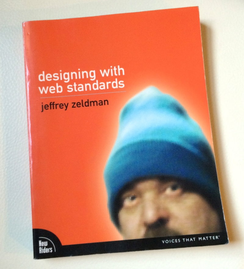 a photo of Jeffrey's book, Designing with Web Standards, showing him wearing the now-famous blue beanie, on an orange cover.